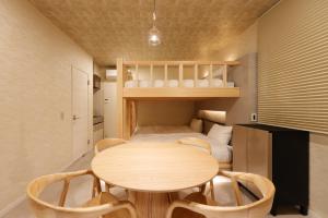 a small room with a table and a bed at HAKORU Tokyo 八炬ル in Tokyo