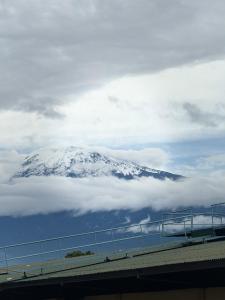 a snow covered mountain in the clouds over a bridge at The new home in Moshi
