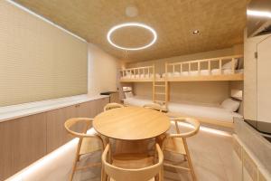 a small room with a table and chairs and bunk beds at HAKORU Tokyo 八炬ル in Tokyo +26 photos