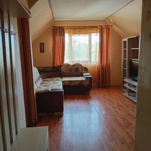 a living room with a couch and a tv at Дарина in Chornomorsk