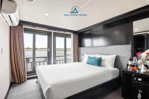 a hotel room with a large bed and a window at Aqua Classic Cruise in Ha Long