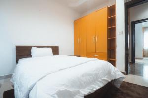 a bedroom with a large white bed and orange cabinets at Spacious 3-Bedroom in Central Ikeja in Ikeja