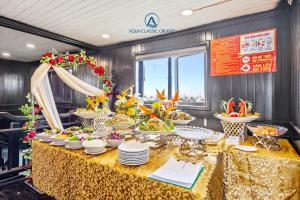 a buffet table with plates and bowls of food at Aqua Classic Cruise in Ha Long