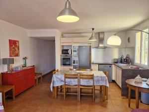 a kitchen with a table and chairs in a kitchen at Le Panoramic in Saint-Florent
