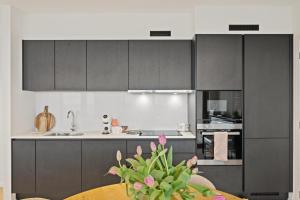 a kitchen with grey cabinets and a table with a plant at Zilt 15 in Ostend