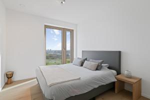 a bedroom with a large bed with a large window at Zilt 15 in Ostend