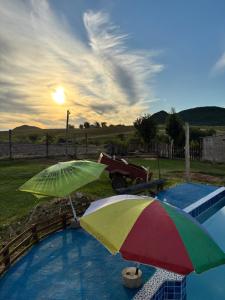 two umbrellas sitting next to a swimming pool at El Atardecer in Lunarejo