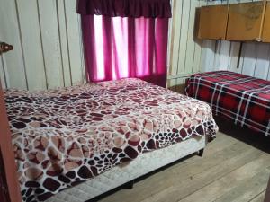 a bedroom with a bed with a brown and white comforter at El Atardecer in Lunarejo