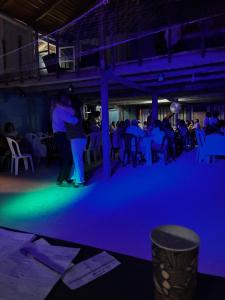 a group of people standing in a room with blue lights at El Atardecer in Lunarejo