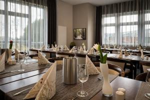 a dining room with tables and chairs and windows at Villa Silva - Oberhof in Oberhof