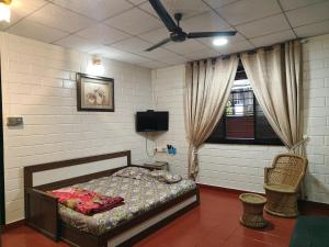 a bedroom with a bed and a television in it at UDUPI HOMESTAY - Cottage House - Dendoorkatte, Udupi in Udupi