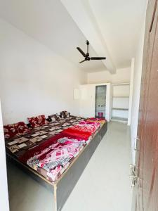 a large bed in a room with a ceiling fan at Shivraj guest house in Ābu Road