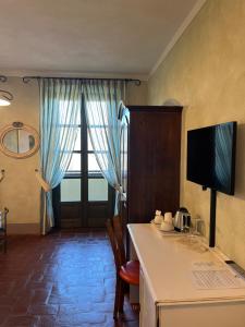 a room with a kitchen with a table and a television at Tenuta Baràc in Alba