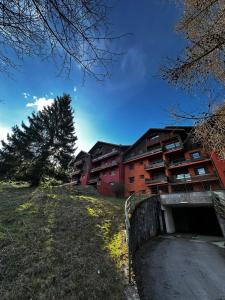 a building on a hill next to a road at Montecampione Prati B in Pian Camuno