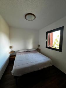 a bedroom with a large bed with a window at Montecampione Prati B in Pian Camuno