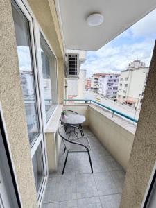 a balcony with a chair and a table on a balcony at Shazam Apartment Central, Stylish & Cozy near AUBG in Blagoevgrad