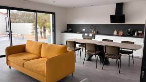 a kitchen with a couch and a table and chairs at Villa Lagune in Les Sables-d'Olonne