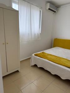 a bedroom with a bed and a dresser and a window at Cringe Boutique APT in Netanya +3 photos