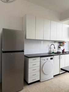 a kitchen with a refrigerator and a dishwasher at Cringe Boutique APT in Netanya