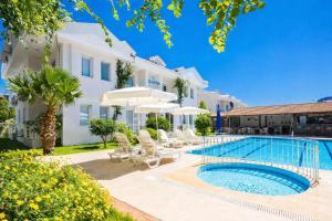 a villa with a swimming pool with chairs and umbrellas at Safak Hotel Dalyan in Dalyan