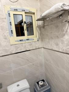 a bathroom with a toilet and a window at Manazil Al Joud -AlSafa منازل الجود - الصفا in Jeddah