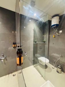 a bathroom with a glass shower with a toilet at Arth Suites Lucknow Gomti Nagar in Lucknow +165 photos