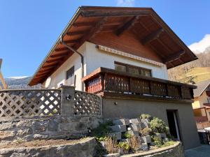 a house with a balcony on top of it at Chalet Ad Alta - Flattach in Flattach