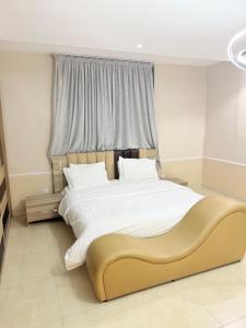 a bedroom with a large bed with a large window at Manazil Al Joud -AlSafa منازل الجود - الصفا in Jeddah