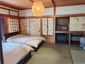 a bedroom with two beds and a chandelier at 山海温泉別荘Hot Spring Villa in Beppu