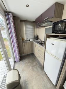 a kitchen with a white refrigerator and a sink at Le G9 - Bungalow lumineux pour 4 avec TV in Boofzheim