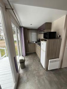 a small kitchen with a refrigerator and a microwave at Le G9 - Bungalow lumineux pour 4 avec TV in Boofzheim