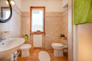 een badkamer met een wastafel, een toilet en een raam bij La Casina Del Canneto in Pergine Valdarno