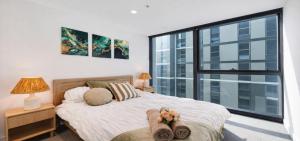 a bedroom with a bed and a large window at Luxe 46th Level 2 Bedroom CBD Apartment with Pool Gym Spa and Views in Melbourne