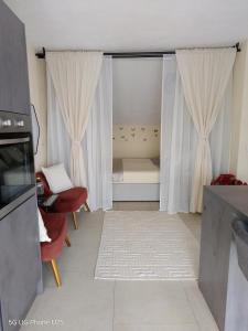 a small living room with a bed and curtains at Apartman Cvita in Bilice +35 photos