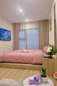 a bedroom with a large bed with a pink bedspread at Homestay Nhà Thu Thu Vinhome Ocean Park in Gia Lâm Pho +20 photos