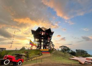 a playground with a red jeep parked in a field at Hostal Amelia Filandia in Filandia