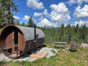 a small circular building with a bench and a swing at Synnfjell hytta in Nord Torpa
