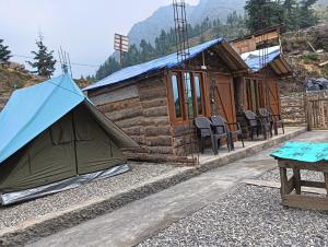 a cabin with a blue tent in front of it at Hill View Cottage in Chakrāta