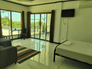 a bedroom with a bed and a couch and a television at Safe Haven Residence in Talibon