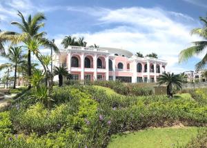 a pink building with palm trees in front of it at Canisa Villas in Phú Quốc +59 photos