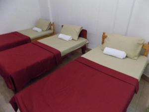 two beds in a room with red and white sheets at Sajee Residence Nilaveli in Trincomalee +4 photos
