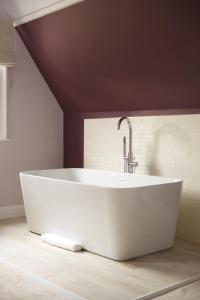 a white bath tub in a bathroom with a ceiling at The Northgate in Bury Saint Edmunds
