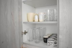a shelf with glass vases and other items on it at Zk House Kythnos in Mérikhas