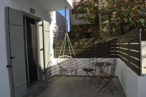 a porch with two chairs and a swing at Zk House Kythnos in Mérikhas +8 photos