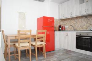 a kitchen with a table and a red refrigerator at Zk House Kythnos in Mérikhas