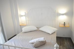 a white bed with two white pillows on it at Zk House Kythnos in Mérikhas