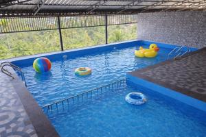 a swimming pool with two rubber ducks in the water at Pullat Suites in Kalpetta +15 photos