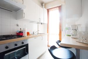 una cucina bianca con piano cottura e lavandino di Appartamenti La Playa a Riccione