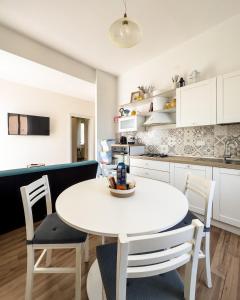 a kitchen and dining room with a white table and chairs at Casa Silvia in Bracciano +21 photos