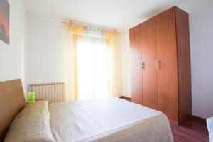 una camera con un grande letto e una finestra di Appartamenti La Playa a Riccione